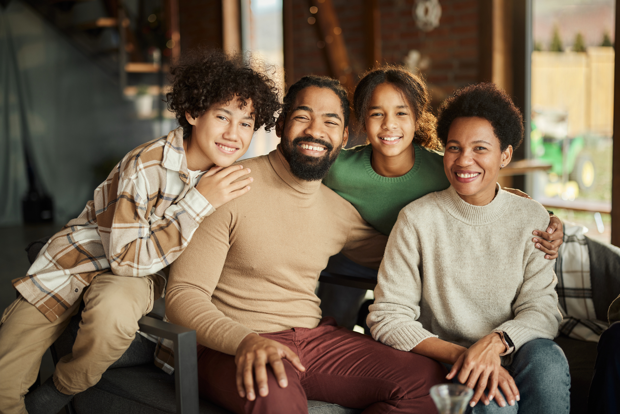 Happy family of four smiles while spending time together at home