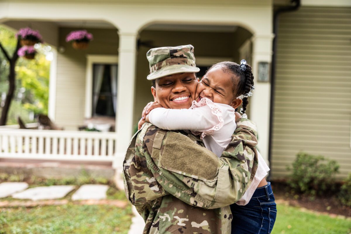 Medium-GettyImages-1670270813-1200×801 Man in military uniform embraces his daughter as he returns home from deployment